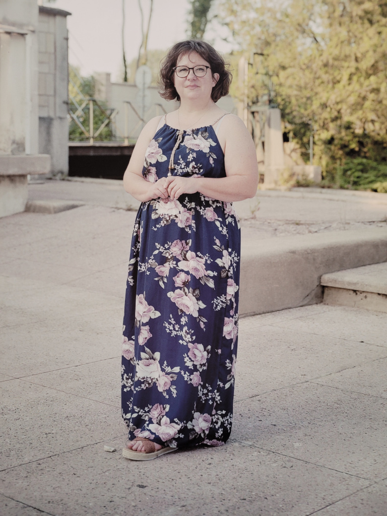 Hélène, adulte, dans la cour nord de la Séravenne, avec la passerelle en arrière plan